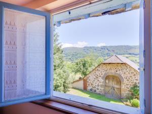 a window with a view of a building at Vic-sur-Cère Family Nest in Vic-sur-Cère