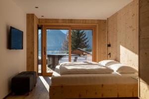 a bedroom with a bed and a large window at Chalet Residenz Mühlermoos - Terrassen Chalet in Ramsberg