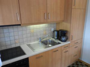a kitchen with wooden cabinets and a sink at Combyre C 024 -COMFORTABLE apartment 4 pers in Veysonnaz
