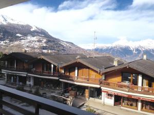 a building with snow covered mountains in the background at Combyre C 024 -COMFORTABLE apartment 4 pers in Veysonnaz