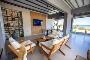 a living room with chairs and a view of the ocean at Fyllis Fine Living Sea view in Asprovalta