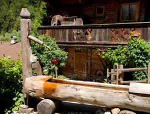 a wooden boat with a flower in it in front of a house at Forsthaus Daringer in Mayrhofen