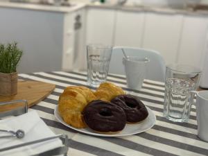 drei Donuts auf einem Teller auf einem Tisch in der Unterkunft RIOJALAND 1B precioso alojamiento en el centro de Lardero in Lardero