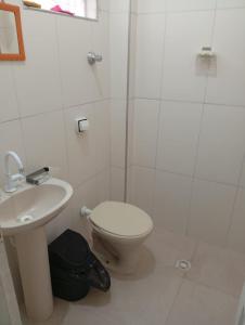 une salle de bain avec toilettes, lavabo et douche dans l'établissement Casa Praia Mongagua - Cantinho Familia pé na Areia, à Mongaguá