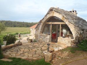 ein kleines Steinhaus mit einem großen Fenster in der Unterkunft chambres du Domaine de Bombes in Mostuéjouls