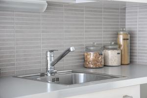 a kitchen counter with a sink and two jars of food at Santa's City Suite by Book Lapland in Rovaniemi