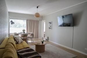 a living room with a couch and a table at Santa's City Suite by Book Lapland in Rovaniemi