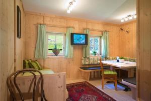 a dining room with a table and a television in a room at Ferienhaus Stillupp in Mayrhofen