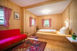 a room with a bed and a red couch at Ferienhaus Stillupp in Mayrhofen