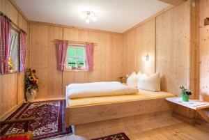 a bedroom with a bed in a room with wooden walls at Ferienhaus Stillupp in Mayrhofen
