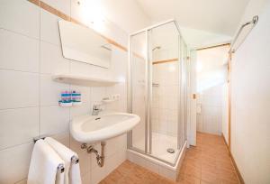 a white bathroom with a sink and a shower at Ferienhaus Stillupp in Mayrhofen