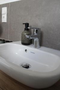 a bathroom sink with a faucet on top of it at Doppelzimmer 1 in Lorup +5 photos