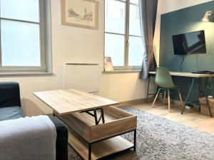 a living room with a table and a desk at Appartement Grand Place de Lille - 2 voyageurs in Lille