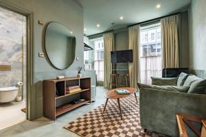 a living room with a couch and a mirror at The Rokxy Townhouses & Residences - Kings Cross in London