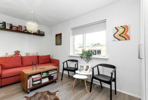 ein Wohnzimmer mit einem roten Sofa und einem Tisch in der Unterkunft Charming top floor apartment with scenic view in Mosfellsbær