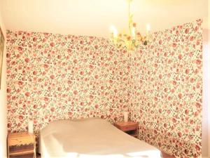 una camera da letto con un letto e una parete decorata con fiori di Historic Dordogne Escape a Villefranche-du-Périgord