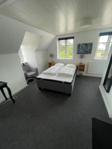 a bedroom with a bed and a chair in it at Øster Hurup Camping in Hadsund +29 photos