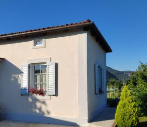 a white house with a window with flowers in it at Ca' dell'Agro in Gorizia