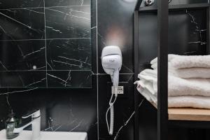 a bathroom with a blow dryer on the wall at Paloka Collection Hotel in Shëngjin +57 photos