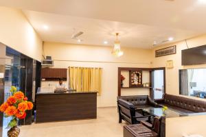 a lobby with a bar and a person in the kitchen at Hotel Amrit Vatika in Satna
