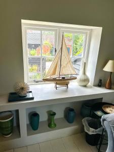 a shelf with a model boat on it in a window at Stylish Hayloft sleeping 4 on Norfolk Broads in Dilham