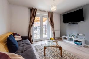 a living room with a couch and a tv at Silver Grove in Stoke on Trent