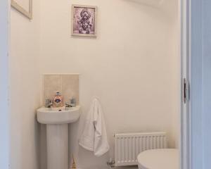 a white bathroom with a sink and a toilet at Silver Grove in Stoke on Trent +10 photos
