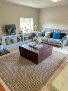 a living room with a couch and a coffee table at Stylish Hayloft sleeping 4 on Norfolk Broads in Dilham