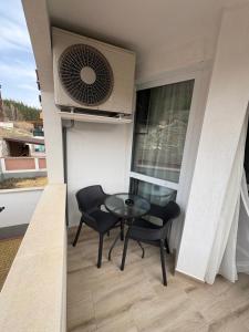 a small balcony with a glass table and chairs at Nikea apart 2 in Velingrad