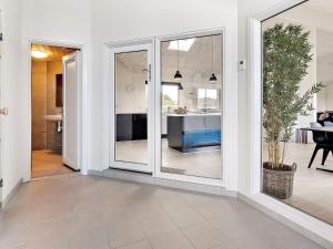 a living room with sliding glass doors and a kitchen at 30 person holiday home in Nørre Nebel in Nørre Nebel +25 photos