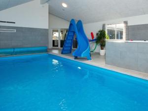 a swimming pool with a blue slide in a building at 30 person holiday home in Nørre Nebel in Nørre Nebel