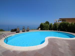 a large swimming pool with two chairs around it at Family Sea-View Retreat in Parghelia in Parghelia