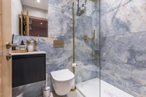 a bathroom with a toilet and a glass shower at The Rokxy Townhouses & Residences - Kings Cross in London