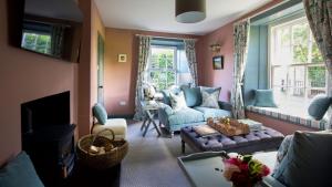 a living room with a blue couch and a tv at East Lodge, Bughtrig in Coldstream