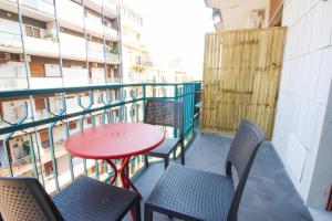 a balcony with chairs and a red table and chairs at Dadà - Luxury Suite in Bari