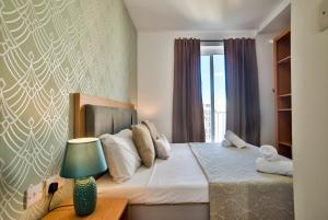 En eller flere senge i et værelse på Sliema 2-bedroom Central Apartments and Penthouse with jacuzzi