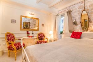 1 Schlafzimmer mit einem großen Bett und 2 Stühlen in der Unterkunft Villa Segalla in Rovinj