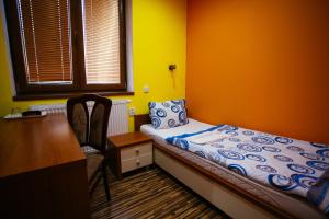 a small bedroom with a bed and a desk at Hotel Centrál Šaľa in Šaľa +26 photos