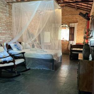 a bedroom with a bed with a mosquito net at Refúgio mar aberto BA in Alcobaça