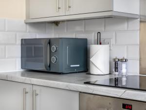 a microwave sitting on top of a kitchen counter at Lavish 1 Bedroom Apartment in London