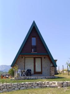 a small stone house with a gambrel roof at WIND Cottage in Žabljak
