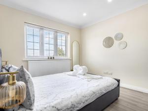 a white bedroom with a bed and a window at Lavish 1 Bedroom Apartment in London +25 photos