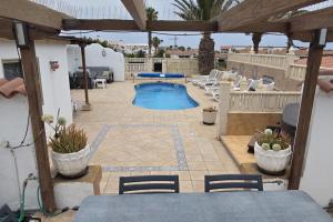 une terrasse avec une piscine, une table et des chaises dans l'établissement 3 Bed Villa - Sleeps 6 - Private Pool - Hot Tub- Parking - Wifi, à San Miguel de Abona