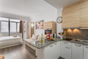 eine Küche mit weißen Schränken und ein Bett in einem Zimmer in der Unterkunft Siempreviva Beach Las Canteras in Las Palmas de Gran Canaria