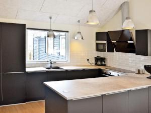 a kitchen with black cabinets and a sink and a window at 5 star holiday home in Liseleje in Liseleje