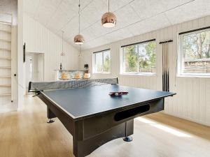 a large ping pong table in a room with windows at Luxury Retreat in Liseleje - By Traum Ferienwohnungen in Liseleje +18 photos