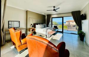 a hotel room with a bed and two chairs at The Cliff Villa Boutique Guesthouse in Hermanus