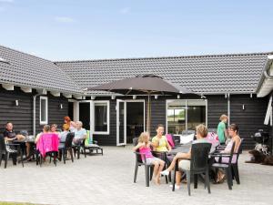 a group of people sitting at tables on a patio at Luxury Retreat with Pool - By Traum Ferienwohnungen in Høruphav