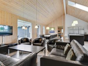 a living room with leather couches and a table at Luxury Retreat with Pool - By Traum Ferienwohnungen in Høruphav +24 photos