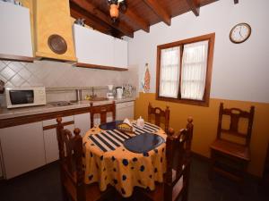 cocina con mesa, sillas y reloj en Cave House in Tenerife with Pool and Beach, en La Orotava 32 fotos más
